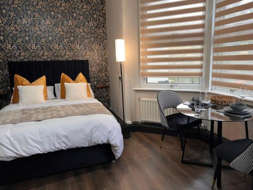a bedroom with a bed and a table with chairs at King Size Studio Apartment Streatham in London
