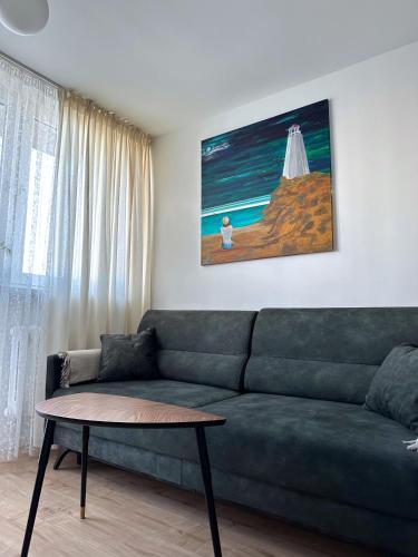 a living room with a green couch and a table at Apartament Teatralny - Komfort w Sercu Miasta Klimatyzacja in Opole
