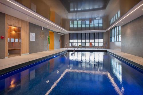 une grande piscine avec de l'eau bleue dans un immeuble dans l'établissement DOMITYS - Le Béryl, à Saint-Ouen