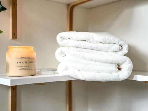 - une pile de serviettes sur une étagère dans une salle de bains dans l'établissement Chic entre Histoire et Modernité, à Paris