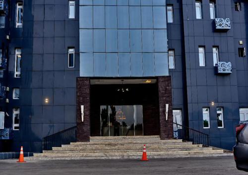 a large building with stairs leading into a doorway at Hotel De Alommah Kubwa Abuja in Abuja