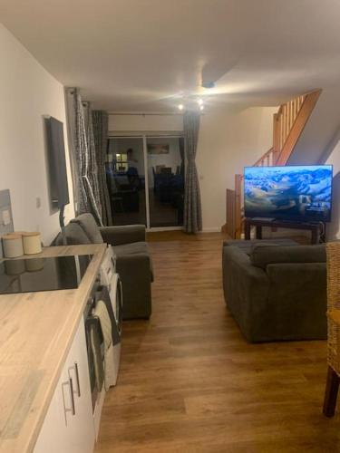 a living room with two couches and a television at 2 Bedroom Home By Felixstowe Sea Front & Beach Street in Felixstowe