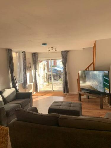 a living room with a couch and a flat screen tv at 2 Bedroom Home By Felixstowe Sea Front & Beach Street in Felixstowe