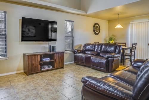 a living room with leather furniture and a flat screen tv at Sunny El Paso Home with Private Yard! in Homestead Meadows South
