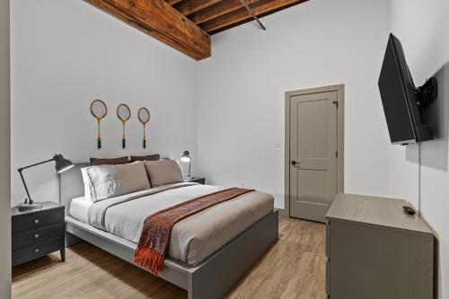 Un dormitorio con una cama y un televisor de pantalla plana. en 1BR Riverfront Loft-Parking-G208, en Saint Louis