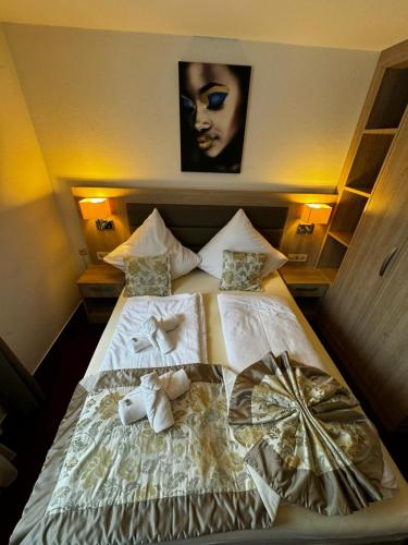 a bed with white sheets and towels on it at S und B Apartments Weingarten in Weingarten