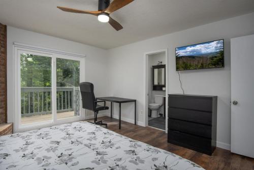 a bedroom with a bed and a desk and a window at Bass Lake Retreat in Pisgah Forest