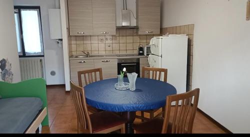 a kitchen with a blue table with chairs and a refrigerator at Appartamento piario in Nasolino