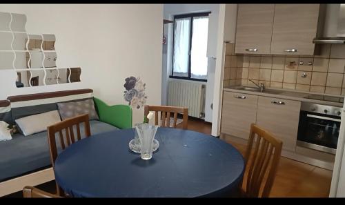 a kitchen and a dining room table with chairs and a blue table sidx sidx sidx at Appartamento piario in Nasolino