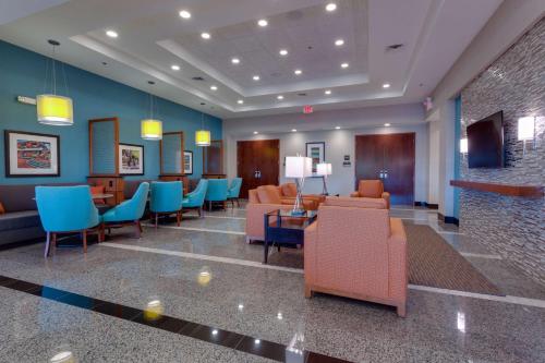 a lobby with a waiting room with chairs and tables at Drury Inn & Suites Gainesville in Gainesville