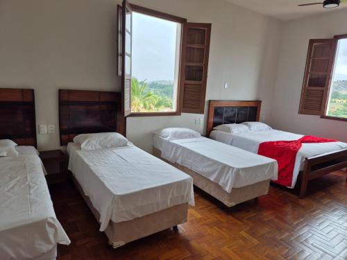 a room with three beds and a window at Boa Vista in Carmo da Mata