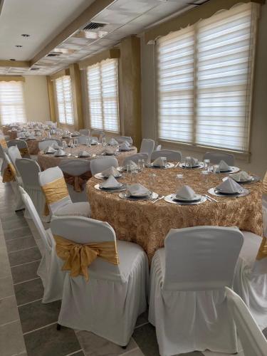 ein Zimmer mit langen Tischen mit weißen Stühlen und einem weißen Tischler in der Unterkunft Hotel Mandarin in Tampico