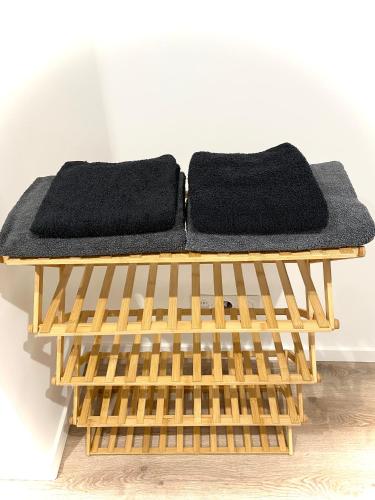 a bench with two black towels on top of it at Relax & Cosy Saint Just Saint Rambert in Saint-Rambert-sur-Loire
