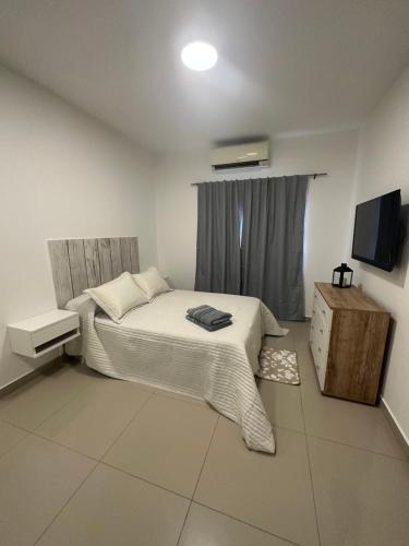 a bedroom with a bed and a television in it at Lo de Hugo in Muñiz