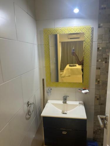 a person taking a picture of a bathroom with a sink at Lo de Hugo in Muñiz