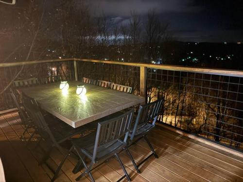 a table and chairs on a deck at night at 1MMView-2Kings-HotTub-PoolTable-Arcade-Waterfall in Seven Devils
