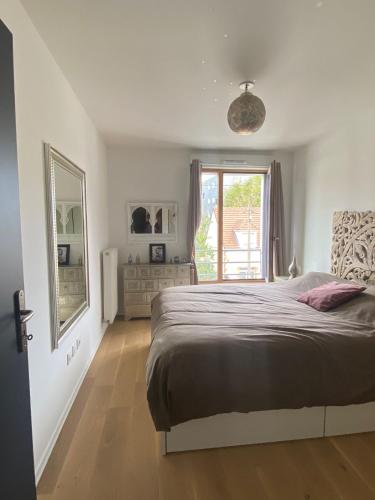 une chambre avec un grand lit et une fenêtre dans l'établissement Parisiano Appartement, à Villejuif