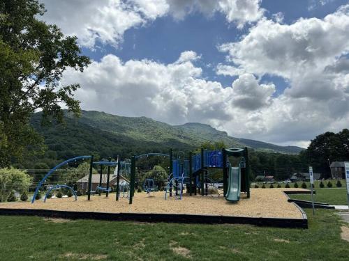 a playground in a park with mountains in the background at 1MMView-2Kings-HotTub-PoolTable-Arcade-Waterfall in Seven Devils