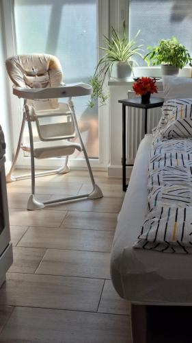 a room with a chair and a table and a bed at Josephine Apartment in Subotica