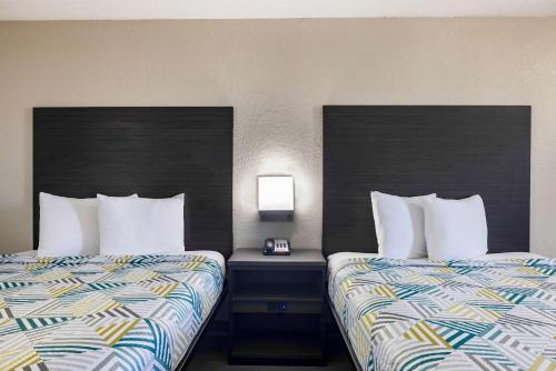 two beds sitting next to each other in a hotel room at Motel 6 Lake Charles, LA in Lake Charles