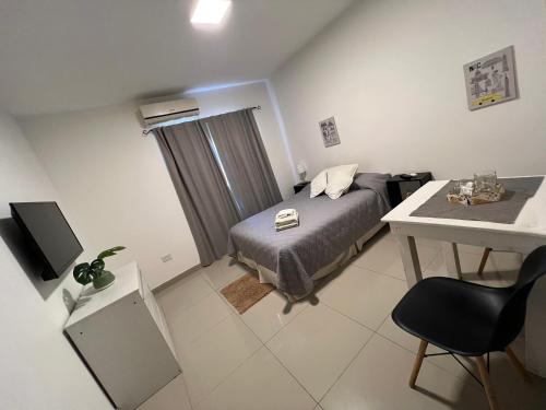 a bedroom with a bed and a table and a desk at Lo de Hugo in Muñiz