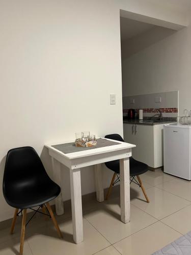 a white table and two chairs in a kitchen at Lo de Hugo in Muñiz