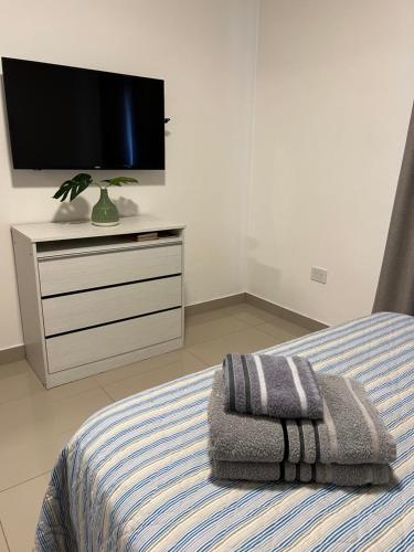 a bedroom with a bed with a television on a dresser at Lo de Hugo in Muñiz