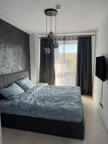 a bedroom with a bed and a large window at Sabo Apartment in Cluj-Napoca