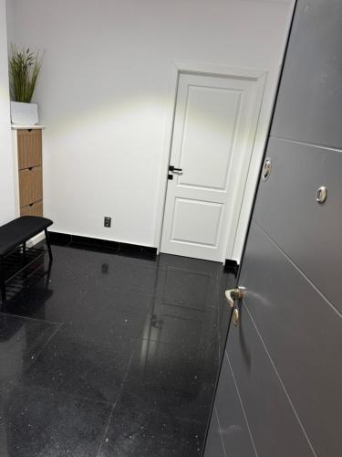 a door in a room with a black floor and a table at Sabo Apartment in Cluj-Napoca