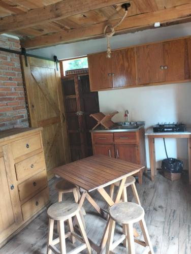 a kitchen with a wooden table and two stools at Acogedora cabaña cerca del desierto de los leones y CC santa Fe in Mexico City