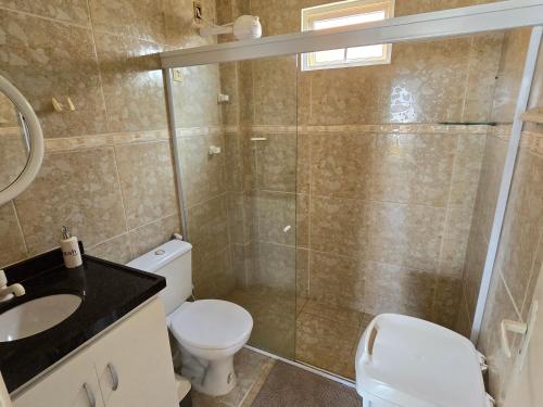 a bathroom with a shower and a toilet and a sink at Praia Bela Paraíba Casa 220 in Pitimbu