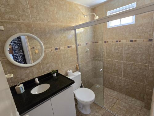 a bathroom with a toilet and a glass shower at Praia Bela Paraíba Casa 220 in Pitimbu