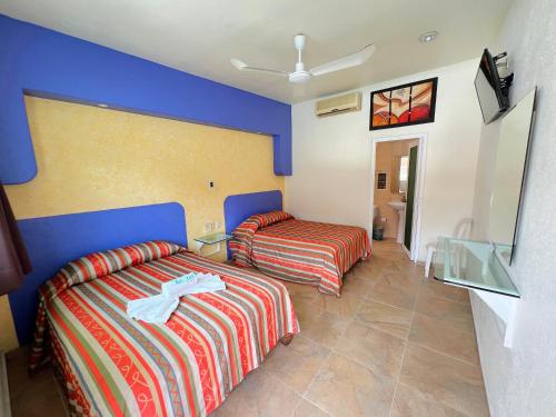 a hotel room with two beds and a window at Hotel Xestalito in Santa Cruz Huatulco