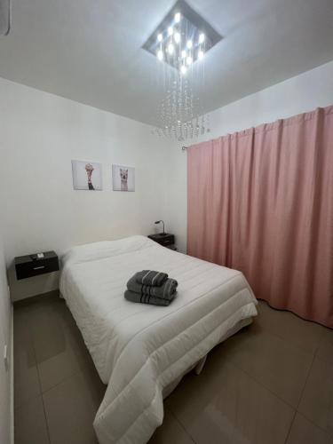 a bedroom with a bed and a pink curtain at Lo de Hugo in Muñiz