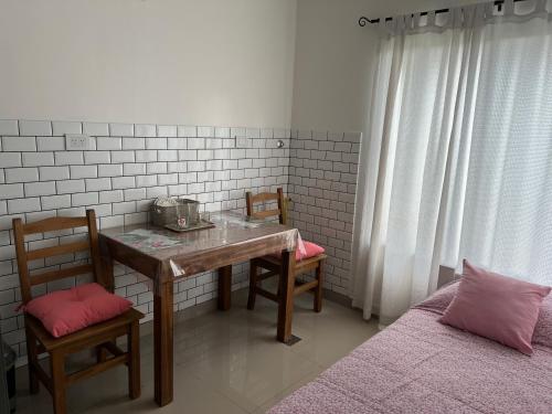 a room with a table and two chairs and a bed at Lo de Hugo in Muñiz