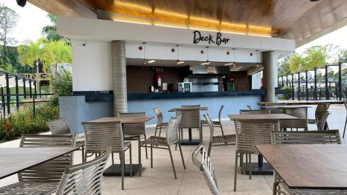 an outdoor restaurant with tables and chairs and a kitchen at Novotel Itu Terras de São José Golf & Resort in Itu