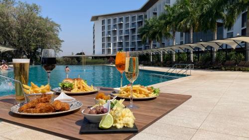 a table with plates of food and glasses of wine at Novotel Itu Terras de São José Golf & Resort in Itu