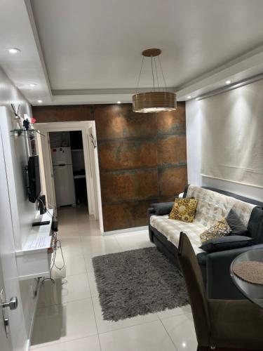 a living room with a couch and a television at Top Floripa Apartment in Florianópolis