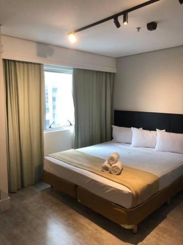 a bedroom with a bed with two towels on it at Apartamento lindo com garagem in Sao Paulo