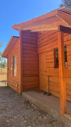 a wooden cabin with a door and a porch at Cabañas Entrearomos 1 in Panguipulli