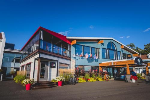 a building on a street with flowers in front of it at Riôtel Carleton-sur-Mer in Carleton sur Mer