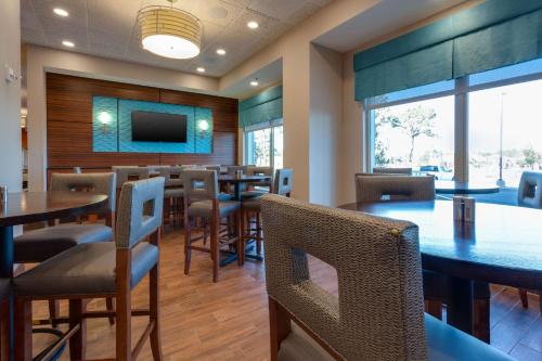 a restaurant with tables and chairs and a flat screen tv at Drury Inn & Suites Gainesville in Gainesville