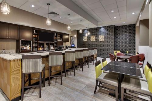 a bar in a restaurant with chairs and tables at Drury Plaza Hotel Milwaukee Downtown in Milwaukee