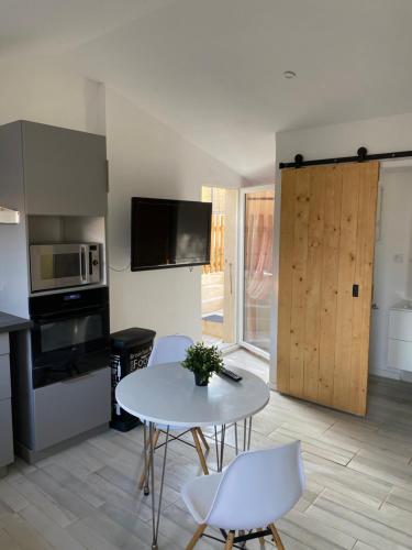 une cuisine avec une table et des chaises et un micro-ondes dans l'établissement Studio à la campagne, à La Tour-dʼAigues