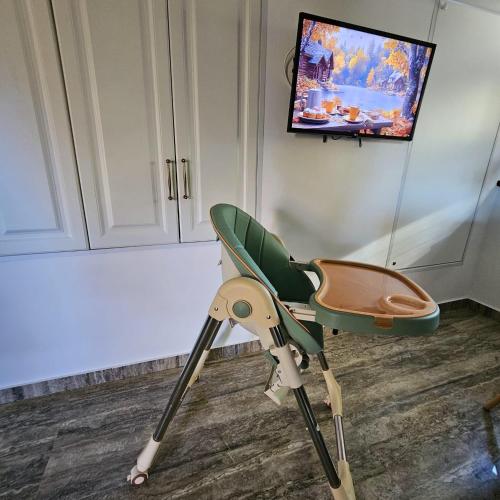 a green high chair in a room with a tv at Wild House in Sinaia