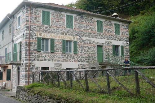 an old stone building with a sign on it at La Foresteria della Beppa in Zeri