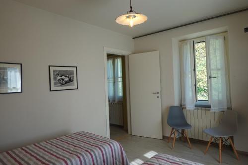 a bedroom with a bed and two chairs and a window at La Foresteria della Beppa in Zeri