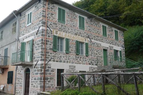 an old stone building with green shuttered windows at La Foresteria della Beppa in Zeri