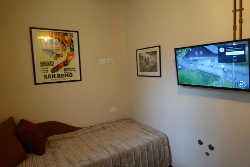 a bedroom with a bed and a flat screen tv at La Foresteria della Beppa in Zeri