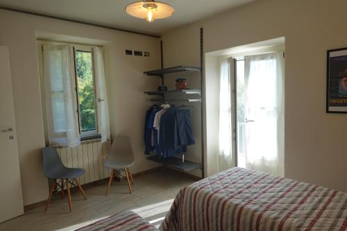a bedroom with a bed and two chairs and a window at La Foresteria della Beppa in Zeri
